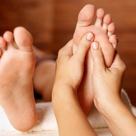 Rustgevende Thaise voetmassage aan linkervoet.